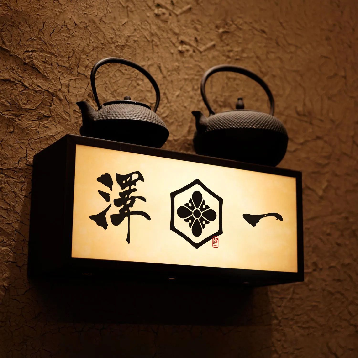 澤一燈箱招牌,上方擺放鐵壺